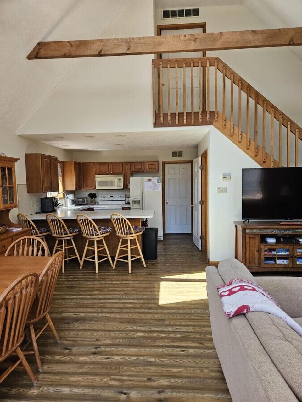 Main living area, dining area, kitchen and stairs to bedroom with king size bed.