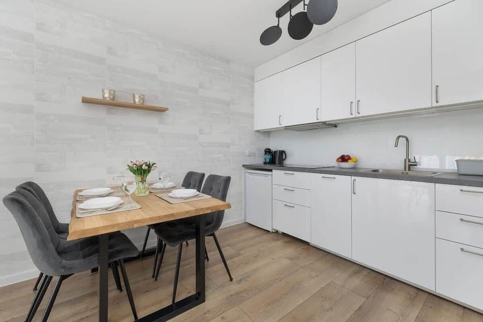 The living room with a sofa, coffee table, and wall-mounted TV is perfect for relaxation and entertainment.