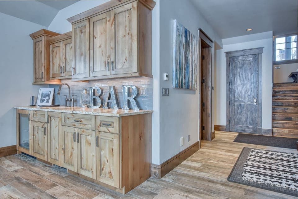 Lower level living room with gas fireplace, mounted TV, and wet bar