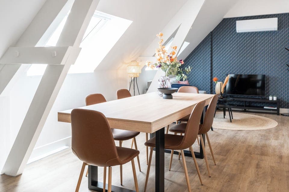 A cozy, contemporary attic dining space with stylish furnishings and a welcoming ambiance, perfect for both casual meals and formal gatherings.
