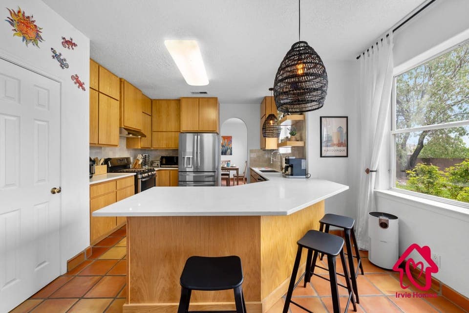 "Modern kitchen with light wood cabinetry and stainless appliances."
