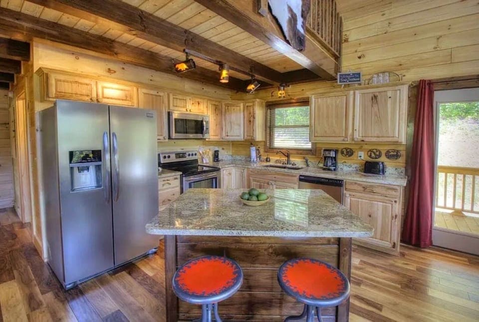 Kitchen with island and seats to be able help with prep work.