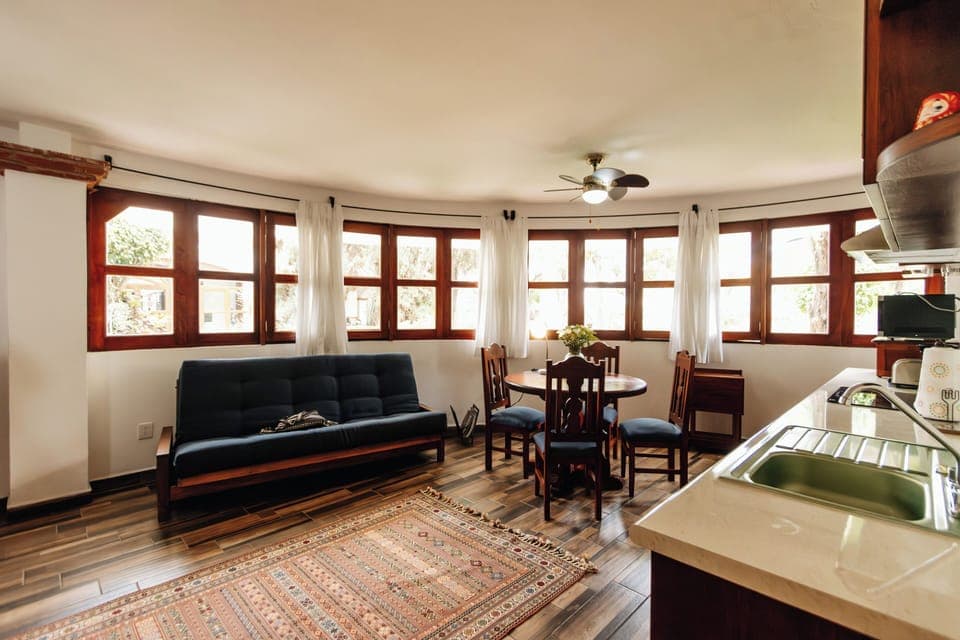 Sofa sleeper in open dining and kitchen area. Stove top, oven and microwave.  