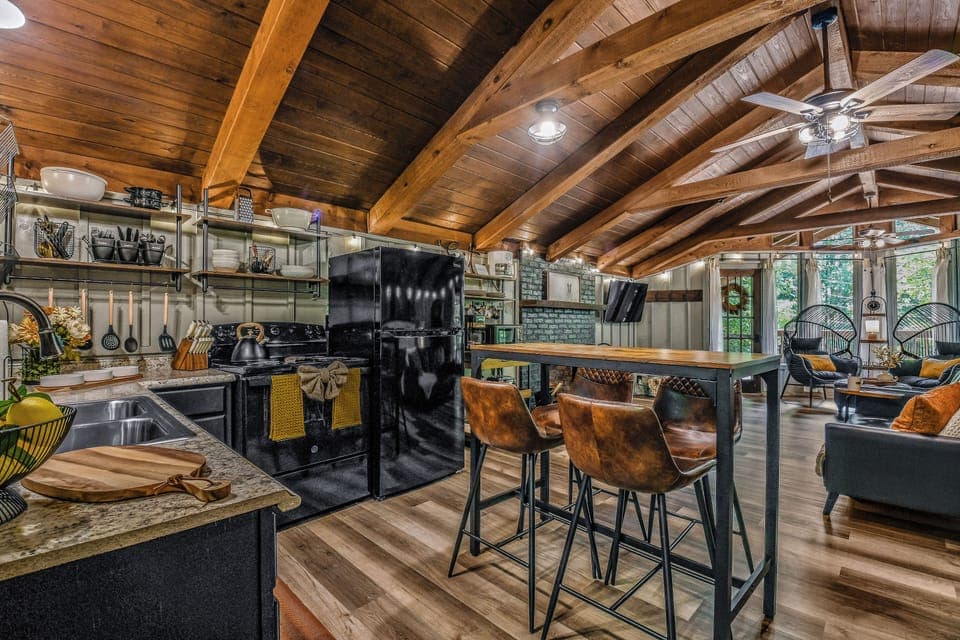 Stylish kitchen bar with leather bar stools and modern black cabinetry at Light'n Bug Bungalow newly renovated bungalow in Townsend, Tennessee