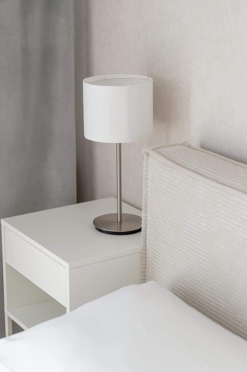 A bedside table with a lamp near the bed ensures comfort during evening reading or relaxation.