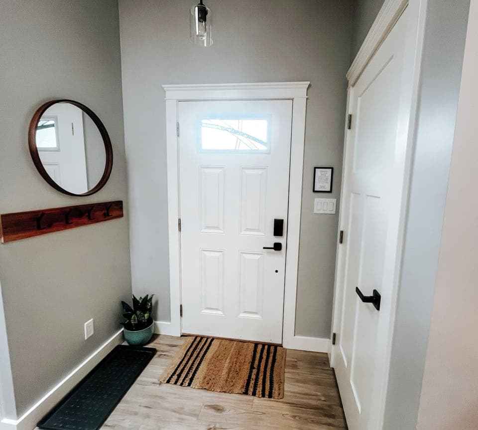 Front entry with mirror, coat hooks and boot tray.