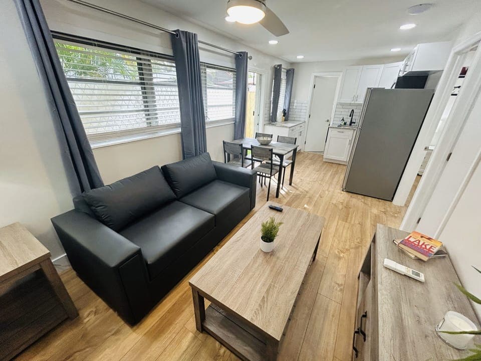 Welcome to our cozy living area, where comfort takes center stage. Relax on the inviting couch, gather around the stylish center table, and catch a glimpse of the seamlessly connected dining area and kitchen. A perfect space for shared moments.