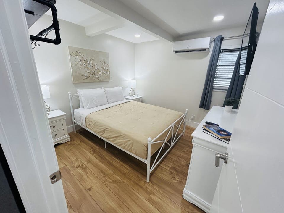 Relax in Bedroom 1 with a queen-size bed, artistic flair from captivating paintings, and functional side tables. Discover a cozy haven designed for restful nights and stylish living. 