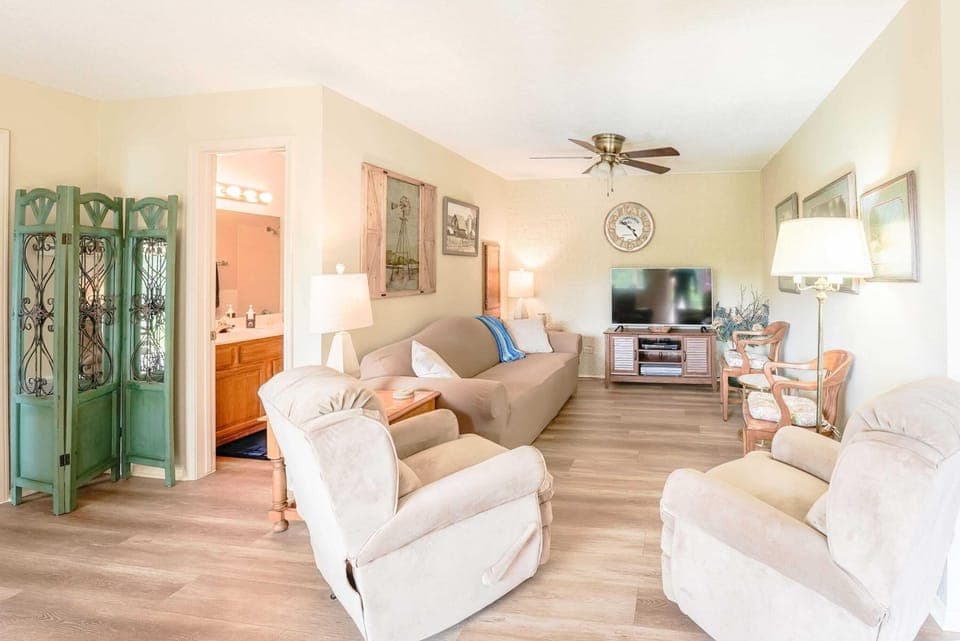 Cozy living room with soft beige and cream-colored furniture with two comfortable recliner chairs. The overall feel is warm and inviting.