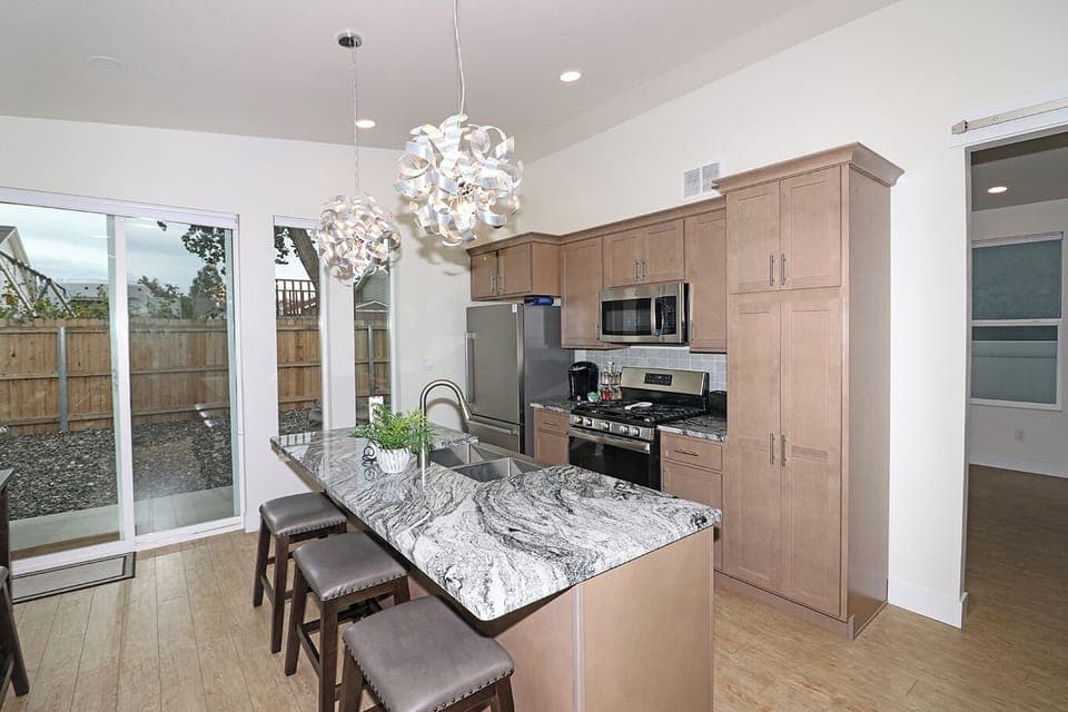Cozy and handy kitchen with 3 comfy bar stools and dining table for 4
