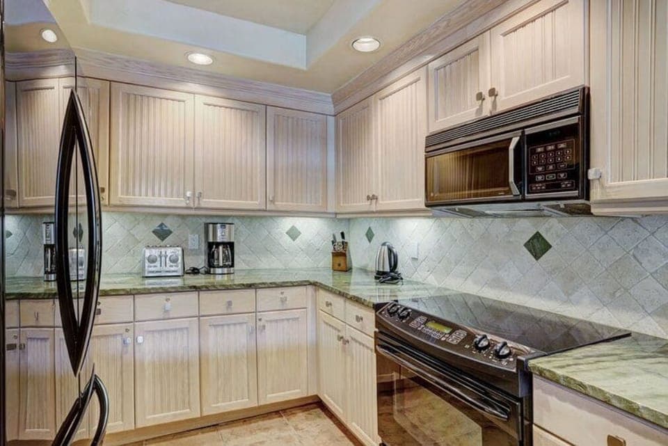 Cook in the fully-equipped modern kitchen, featuring stainless steel appliances, granite countertops, and ample cabinetry for all your culinary needs.