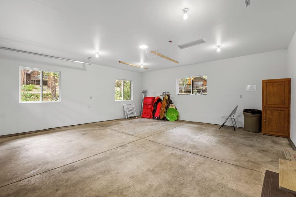 Two car garage with sleds and skimmers for winter fun.