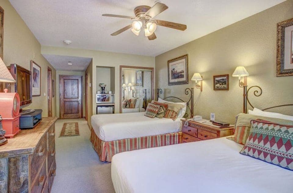 Rest in the rustic bedroom featuring a comfortable king-sized bed, ceiling fan, and cozy decor that creates a welcoming atmosphere.
