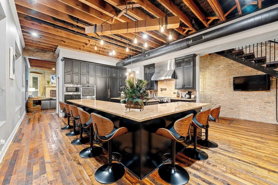 Sleek kitchen w/ dark cabinetry, stainless appliances, and a layout made for cooking together.