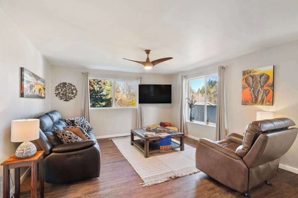 Relax in the living room with reclining leather seating, a big-screen TV, and beautiful views of the surrounding neighborhood. 