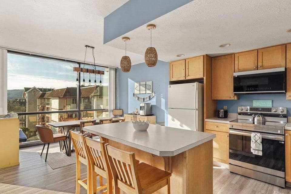 Fully equipped kitchen with island seating, modern appliances, and bright dining area—perfect for meals and gatherings.