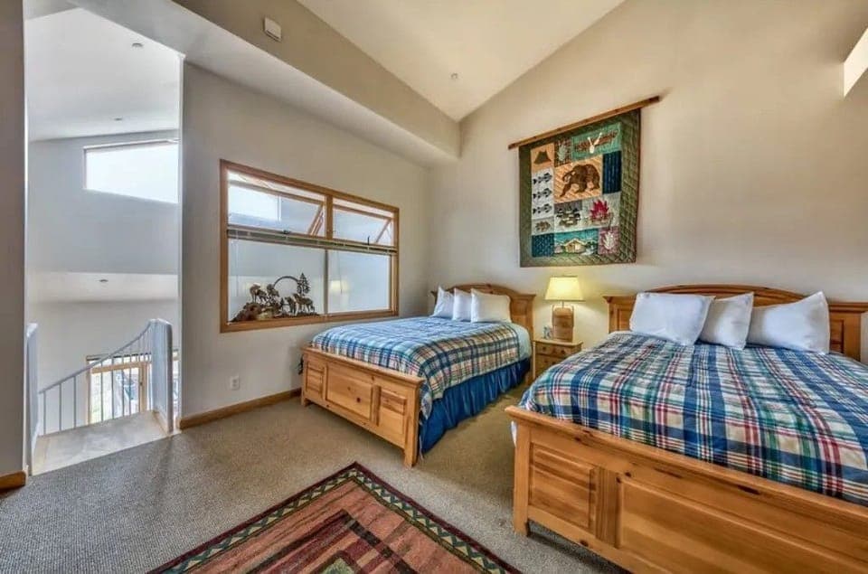 Perfect for friends or family, this cozy bedroom features two twin beds, colorful bedding, and a warm, inviting atmosphere.