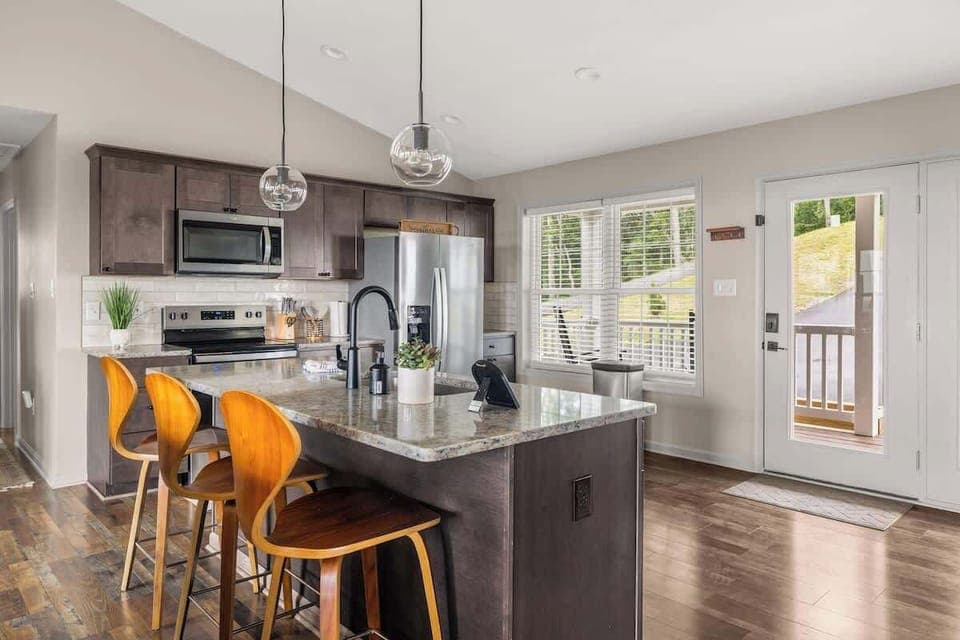 Modern kitchen with island, breakfast bar, and easy access to the deck