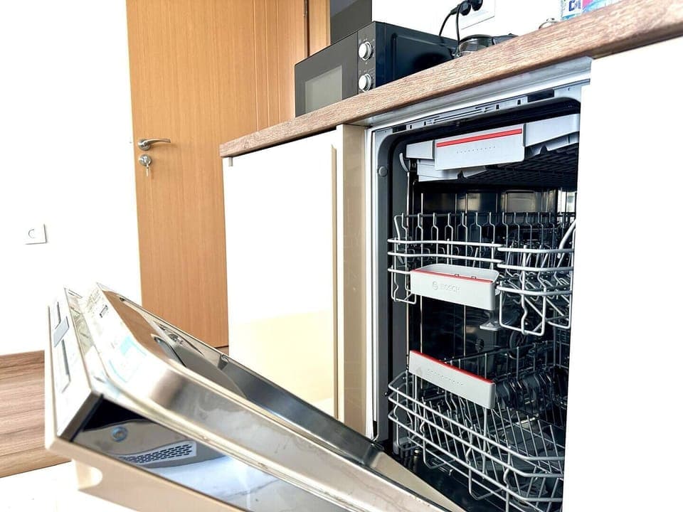 Experience the convenience of modern living with a state-of-the-art dishwasher, seamlessly integrated into the kitchen's sleek design. Perfect for effortless cleanup, leaving you more time to enjoy your stay.