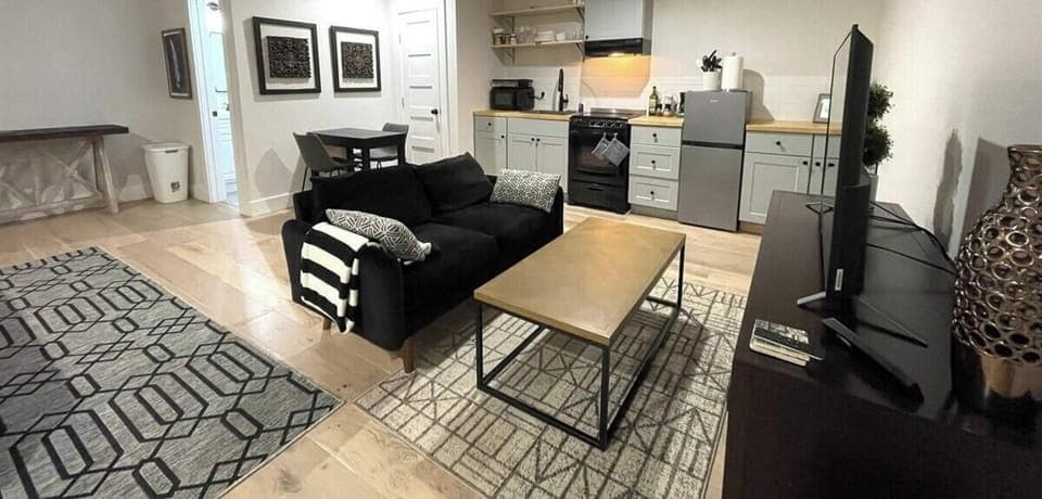 Modern and inviting open-concept living space with a fully equipped kitchenette, chic décor, and plush seating—ideal for a relaxing escape.