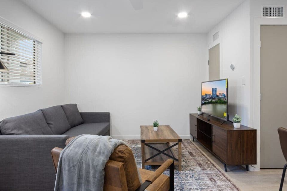 Bright and airy living room with plush seating, a large TV, and tasteful decor, creating the perfect space for relaxation and entertainment.