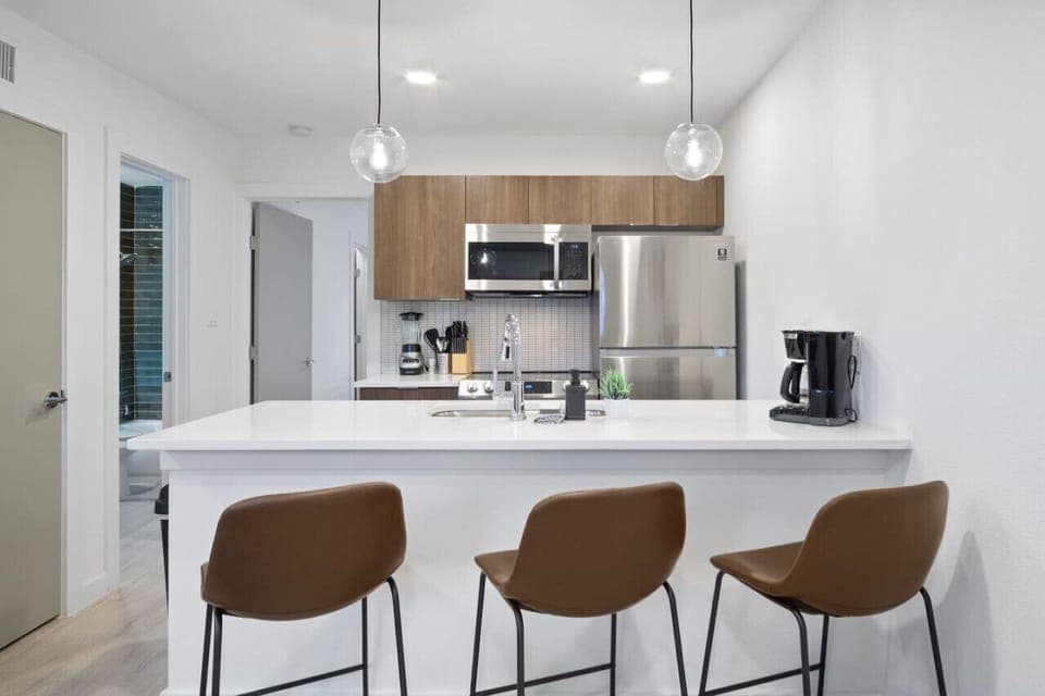 This contemporary kitchen is a chef's dream, featuring a large island, modern stainless steel appliances, and sleek cabinetry. The open layout ensures you can cook and entertain effortlessly, making it the perfect space for culinary creativity and social