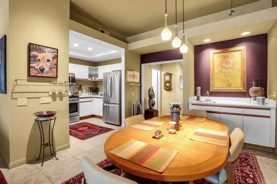Dining area with modern lighting and open kitchen in Palm Springs condo