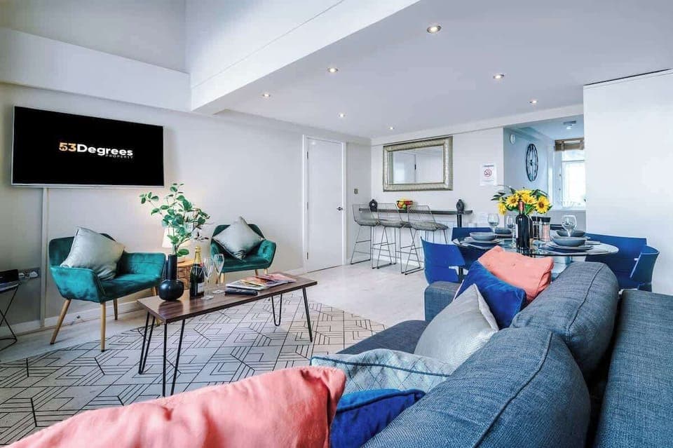 The open-plan living room and dining area benefit from a 50-inch Smart TV, a 4-seater dining table,  a 3-seater breakfast bar, plenty of space to sit down in the evenings and a double sofa bed.