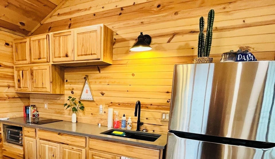 Kitchenette with full size refrigerator and top freezer.