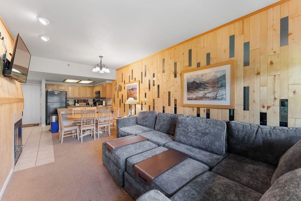 Living room featuring a queen size sleeper sofa, flat screen TV, and balcony access to incredible mountain views.