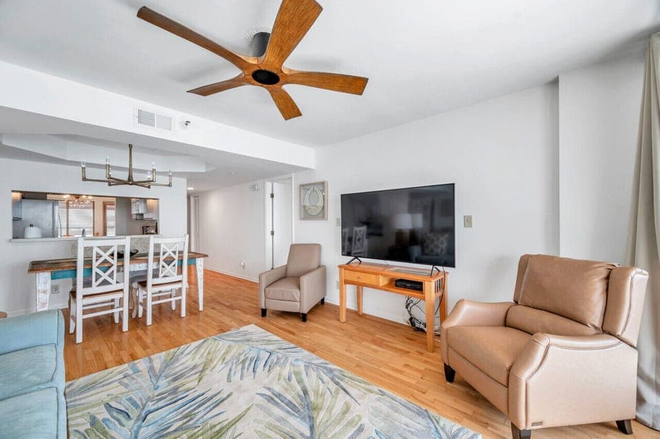 Relaxed living space w/ cozy seating, TV & warm wood floors.