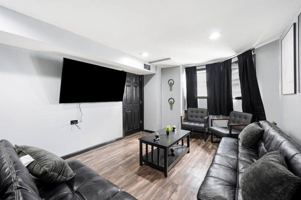 living room with 2 futons and 2 chairs - 65 inch TV