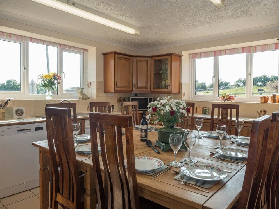 Fitted kitchen; microwave, dining table with ten chairs, windows overlooking the gardens