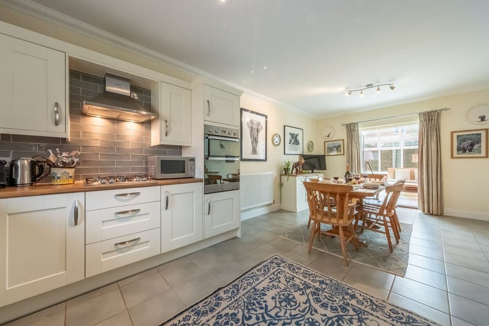 Hector's Hideaway, Wells-next-the-Sea: Kitchen with double electric oven, gas hob, dishwasher, washing machine, microwave, full height fridge/freezer and Nespresso coffee machine. The dining end of the kitchen has a table with six chairs
