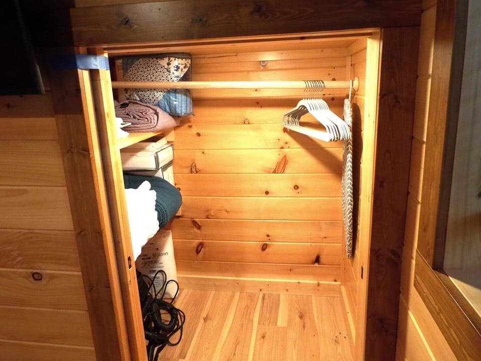 Bedroom closet with hangers and shelves with extra linens