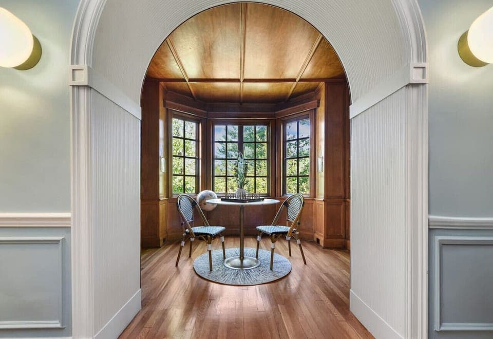 Sun-filled tea room with curved windows and cozy seating