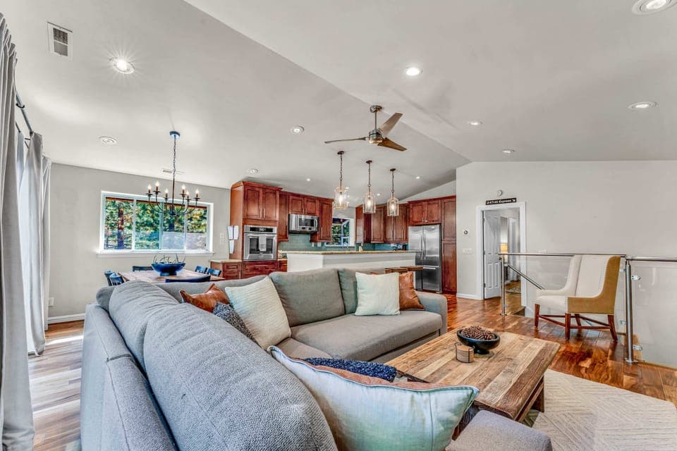 Main Living Space: upper floor, open layout, inviting living room with 65” smart TV, well-equipped kitchen, 6-person dining table, access to deck