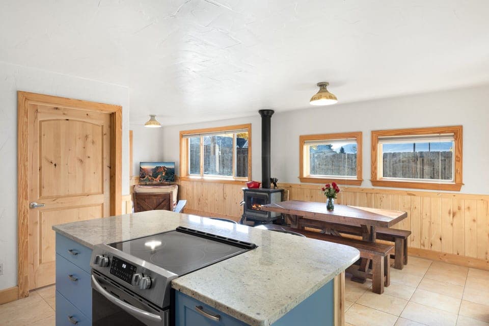 Fully equipped kitchen with stainless steel appliances and granite countertops which opens into the living area and dining area.
