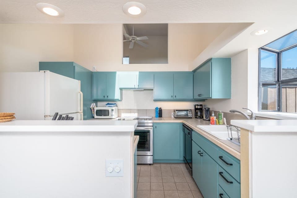 Kitchen with toaster oven, drip coffee pot, microwave, kettle and more