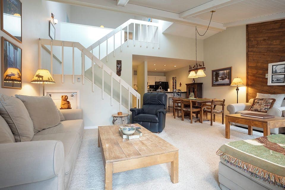 Unwind in this spacious living room featuring vaulted ceilings, cozy seating, and rustic mountain charm perfect for your getaway.