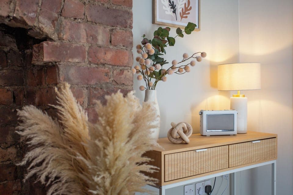 The arrangement of pampas grass in the foreground adds a natural, bohemian touch, creating a warm and inviting atmosphere. 