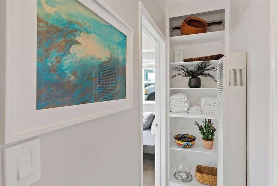 The small hallway from the living room to the primary bedroom. Bath and beach towels provided for your convenience!