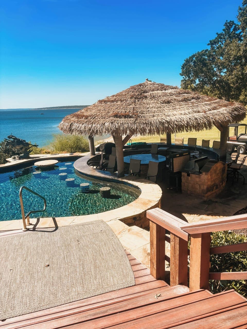 Resort style infinity edge pool with swim up bar and tiki.