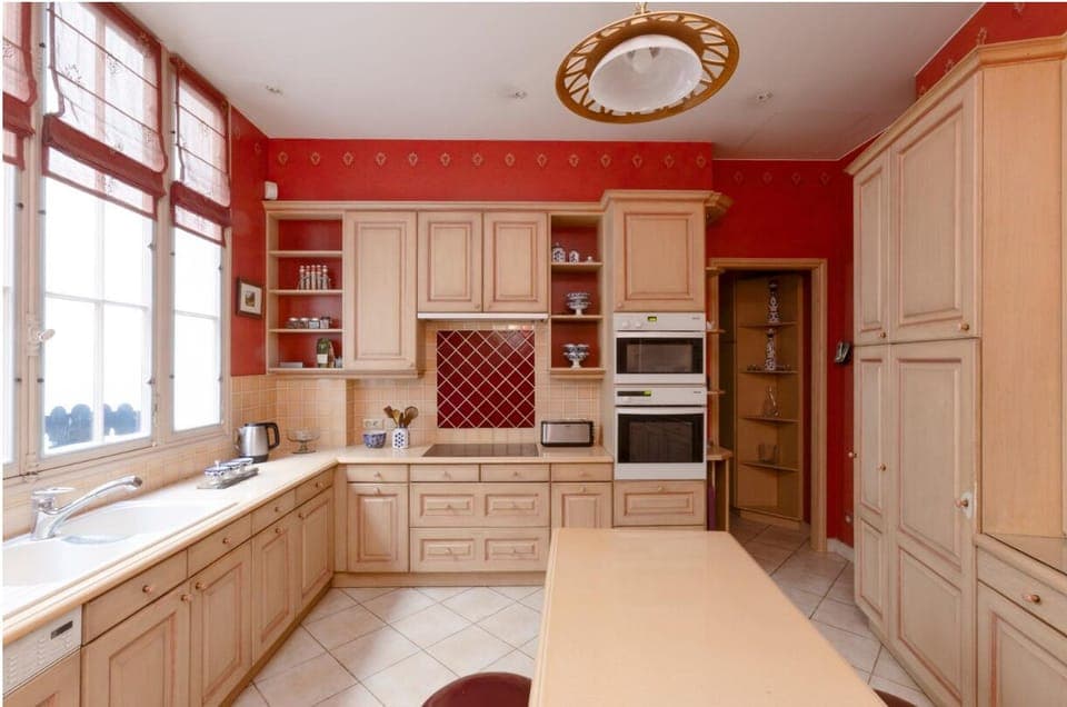 Kitchen is traditionally laid out with blonde wooden cabinets,latest appliances
