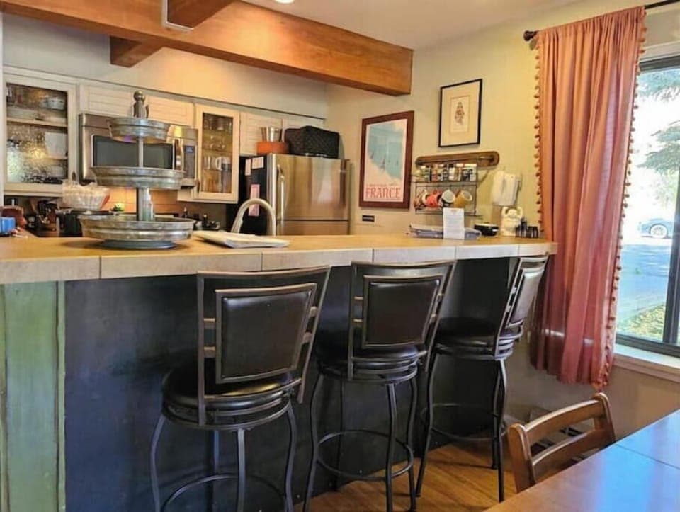Counter and barstools looking into galley kitchen