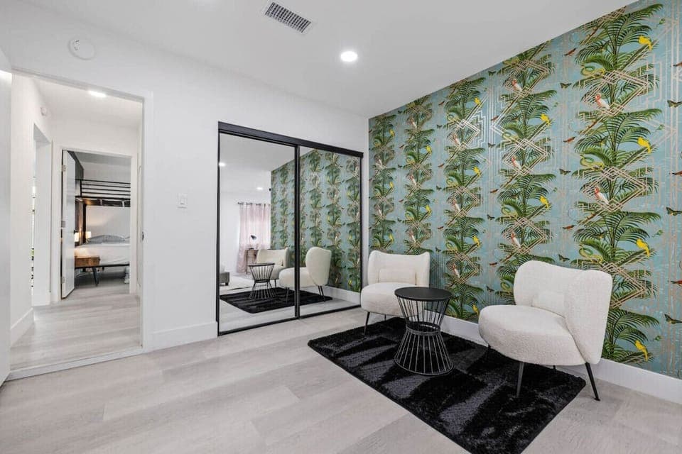 Contemporary bedroom w/ mirrored closet, bold wallpaper & a polished, modern style.