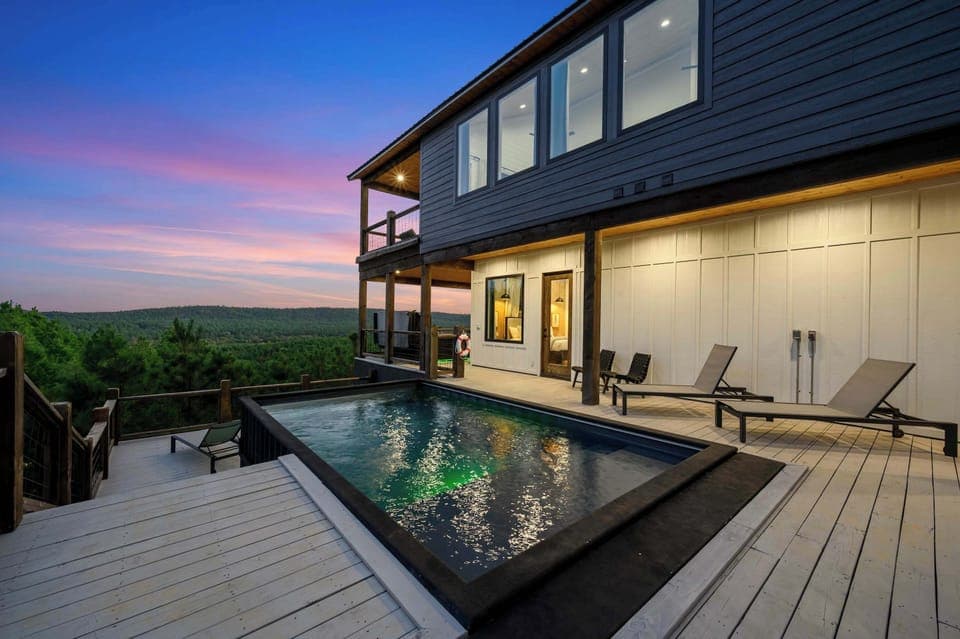 Scenic luxury cabin with illuminated private pool and sunset views—relax in comfort and style.
