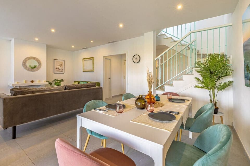 Living room 6-person dining area with glass doors leading to the terrace, pool, and gardens