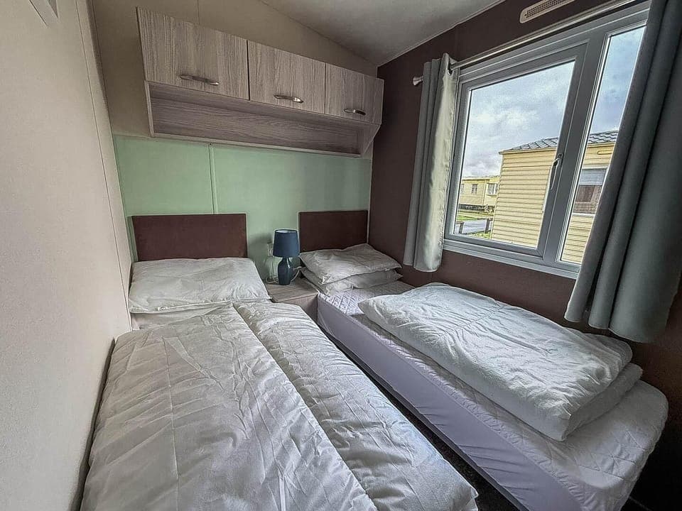 Cozy twin bedroom with bright window views and modern comfort