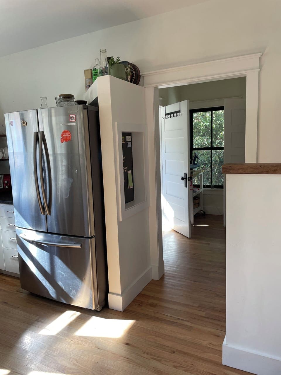 Stainless steel fridge & freezer. Entryway into laundry area, pantry & bathroom